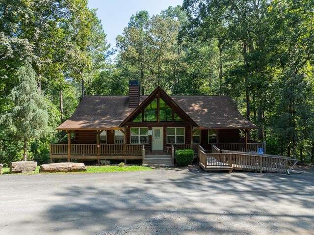 log home featuring covered porch