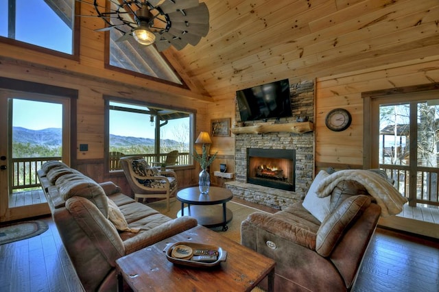 living room featuring wood walls, dark wood-type flooring, and a mountain view