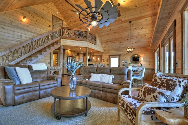 carpeted living room with wooden ceiling, ceiling fan, wood walls, and high vaulted ceiling