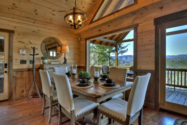 dining area featuring lofted ceiling, a notable chandelier, dark hardwood / wood-style floors, and a mountain view