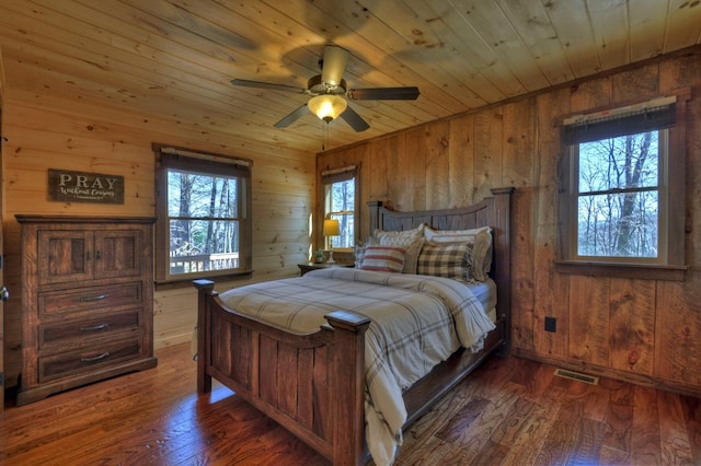 bedroom with wood ceiling, wooden walls, and dark wood-type flooring