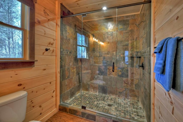 bathroom featuring walk in shower, wood walls, and toilet