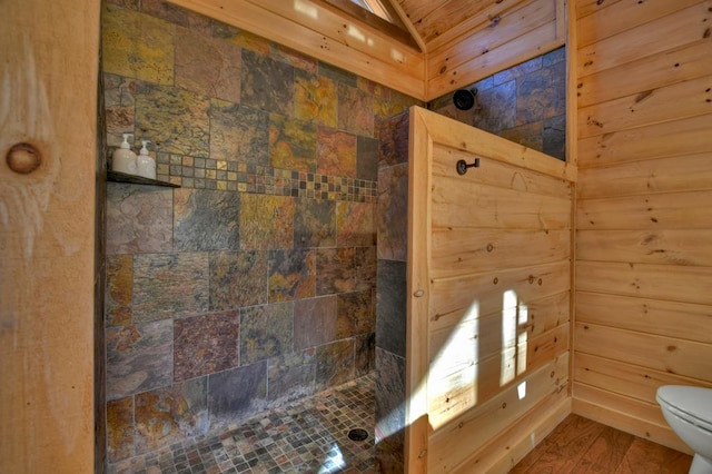 bathroom featuring toilet, a tile shower, and hardwood / wood-style flooring