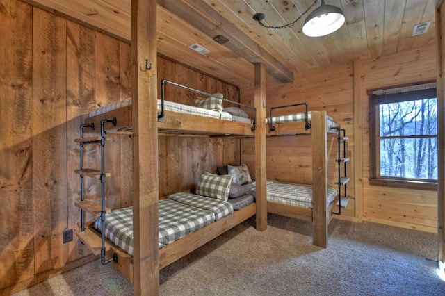 bedroom with carpet, wood walls, and wooden ceiling