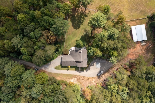 bird's eye view with a wooded view