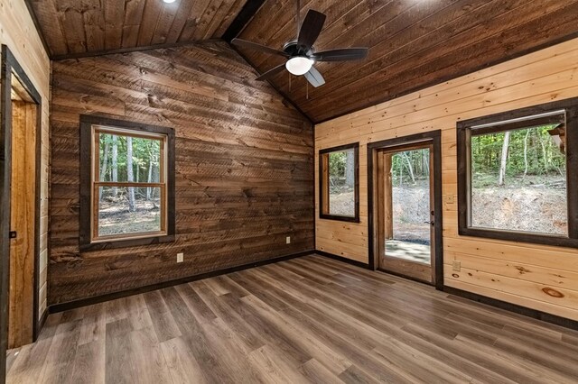 unfurnished room featuring ceiling fan, wood walls, wooden ceiling, and concrete floors