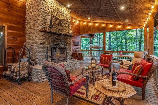 sunroom featuring wood ceiling, an outdoor stone fireplace, and vaulted ceiling