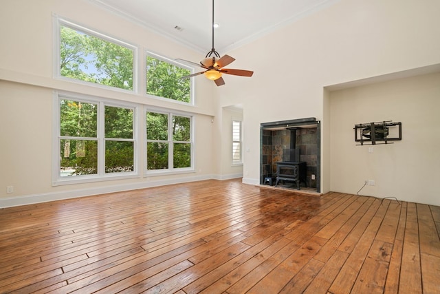 705 Brown Deer Dr, Talking Rock, GA 30175 - unfurnished living room with a wood stove, a ceiling fan, wood-type flooring, ornamental molding, and a towering ceiling