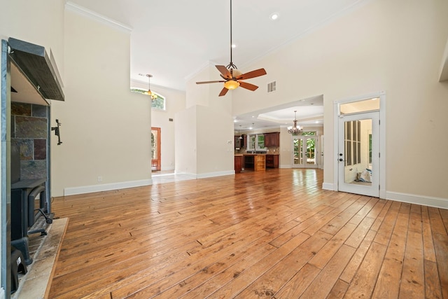 705 Brown Deer Dr, Talking Rock, GA 30175 - unfurnished living room with ornamental molding, a chandelier, a ceiling fan, light wood-style floors, and a wood stove