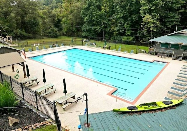 community pool with fence and a patio