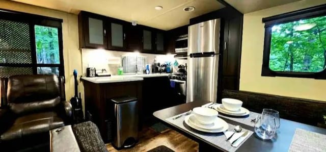 kitchen featuring glass insert cabinets, light countertops, and freestanding refrigerator