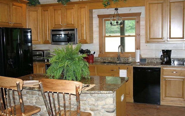 kitchen featuring black appliances, a notable chandelier, stone countertops, hanging light fixtures, and sink