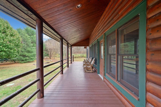 wooden deck featuring a lawn and covered porch