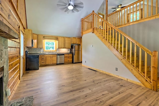 kitchen featuring tasteful backsplash, stainless steel appliances, sink, a high ceiling, and light hardwood / wood-style floors