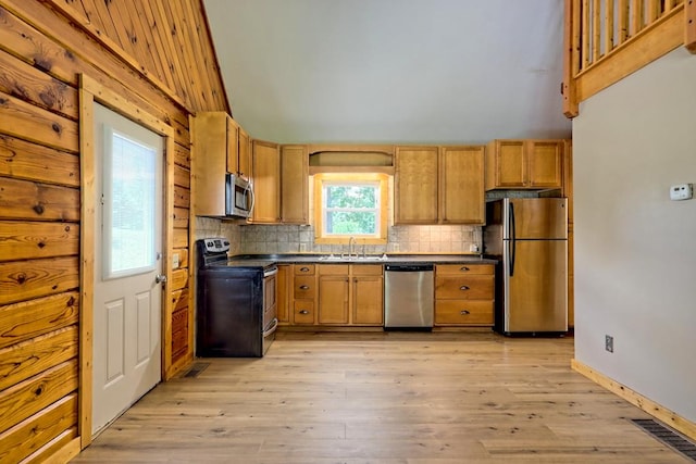 kitchen featuring appliances with stainless steel finishes, tasteful backsplash, light hardwood / wood-style flooring, and sink