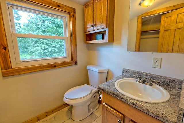 bathroom with tile patterned flooring, vanity, and toilet