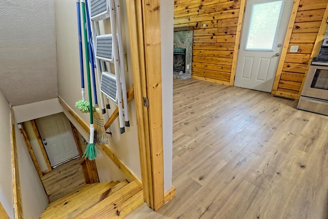 interior space with lofted ceiling, cooling unit, light hardwood / wood-style flooring, a fireplace, and stainless steel range oven