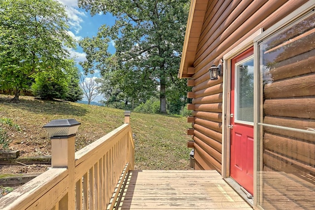 wooden terrace featuring a lawn