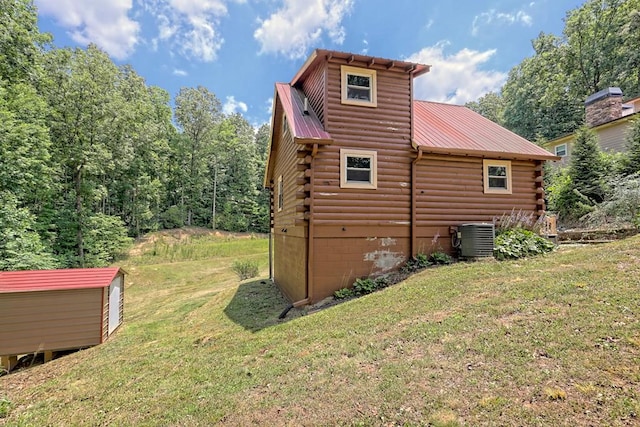 exterior space with central AC unit and a lawn