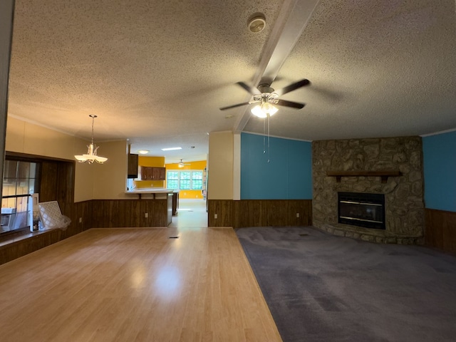 1146 Marrestop Rd, Murphy, NC 28906 - unfurnished living room featuring wainscoting, a textured ceiling, wood walls, a ceiling fan, and a stone fireplace