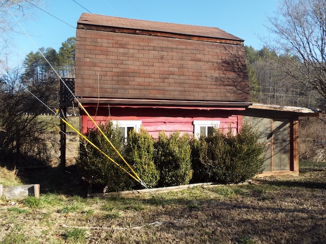 view of property exterior with a shingled roof