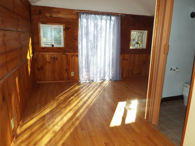 foyer with wood finished floors and wooden walls