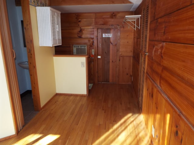 hall with a wall mounted AC and light wood-style floors