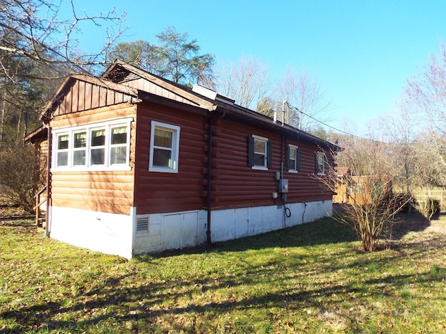 view of property exterior featuring crawl space, log siding, and a lawn