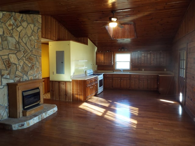 kitchen featuring lofted ceiling, a sink, light countertops, electric panel, and gas range gas stove