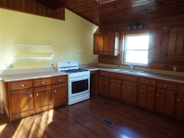 kitchen featuring a sink, visible vents, light countertops, brown cabinetry, and white gas range