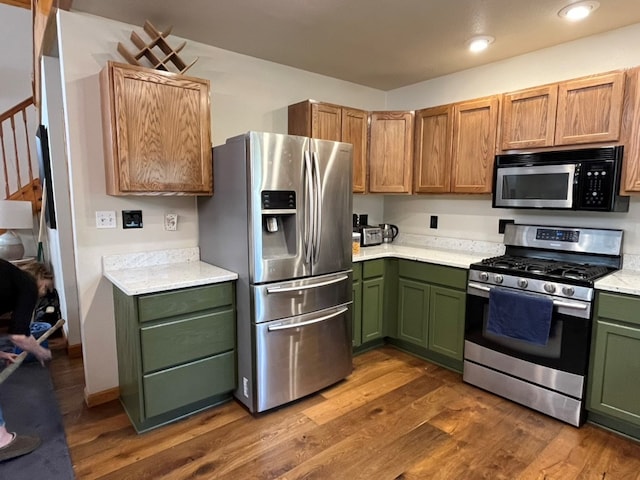 kitchen featuring green cabinets, recessed lighting, dark wood-style flooring, light countertops, and stainless steel appliances