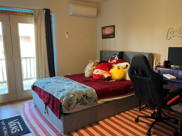 bedroom featuring wood finished floors and an AC wall unit