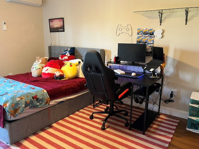 bedroom featuring baseboards, a wall unit AC, and wood finished floors