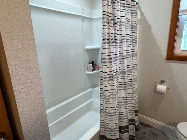 full bath featuring toilet and baseboards