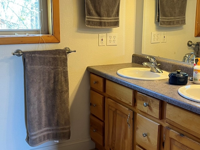 bathroom featuring a sink and double vanity