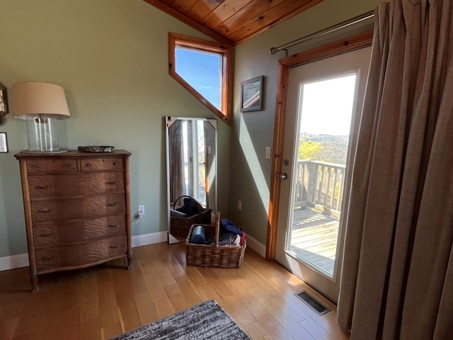 entryway featuring visible vents, baseboards, wood ceiling, light wood-style flooring, and lofted ceiling