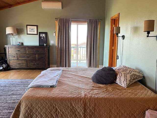 bedroom with a wall mounted AC, lofted ceiling, access to exterior, and wood finished floors
