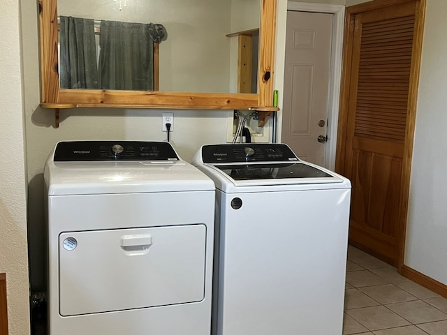 laundry room featuring laundry area, light tile patterned flooring, baseboards, and washing machine and dryer