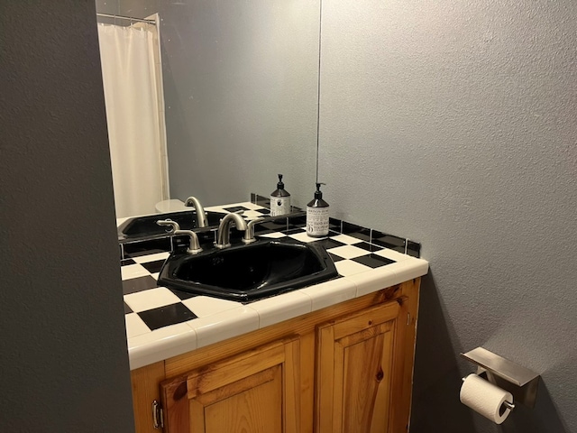 bathroom with vanity and a textured wall