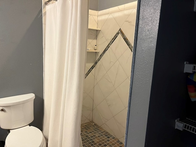 full bath with toilet and a stall shower