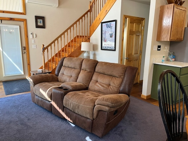living room featuring an AC wall unit, carpet flooring, and stairs