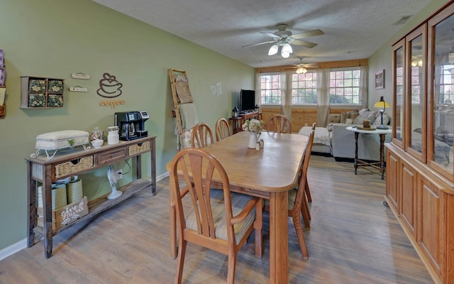 dining room featuring ceiling fan, a textured ceiling, and light wood-type flooring