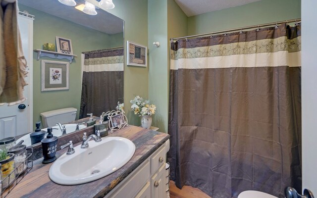 bathroom with vanity, toilet, and walk in shower