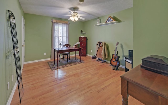 home office with ceiling fan, a textured ceiling, and light wood-type flooring