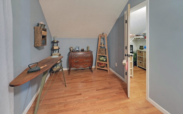 interior space with lofted ceiling, light hardwood / wood-style floors, and a textured ceiling