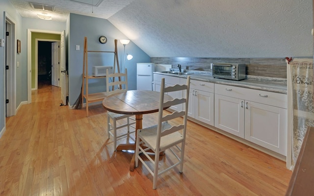 kitchen with white cabinetry, white appliances, sink, and light wood-type flooring