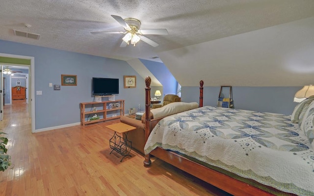 bedroom with lofted ceiling, ceiling fan, hardwood / wood-style flooring, and a textured ceiling