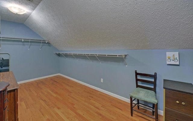 spacious closet featuring wood-type flooring and vaulted ceiling