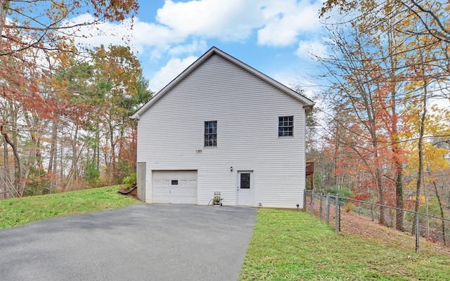 view of side of home with a garage and a lawn