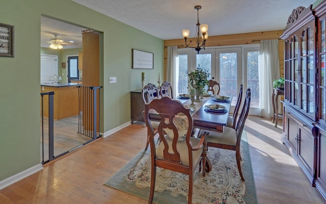 dining room featuring light hardwood / wood-style floors, a textured ceiling, and a notable chandelier